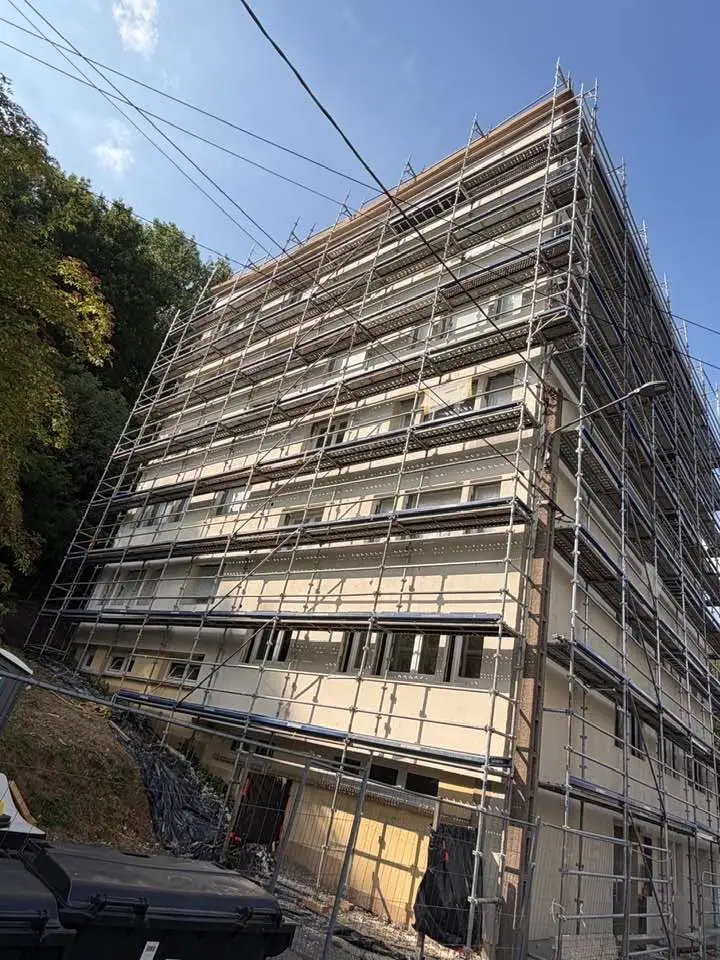 Façade latérale de l’immeuble sous échafaudage, panneaux isolants posés sur plusieurs niveaux.