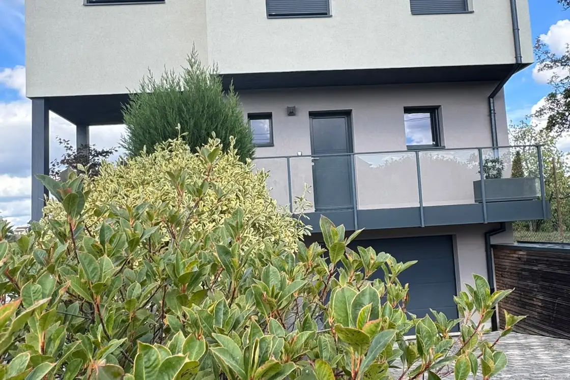 Angle d’une maison contemporaine dont les deux volumes ont reçu un enduit de finition clair