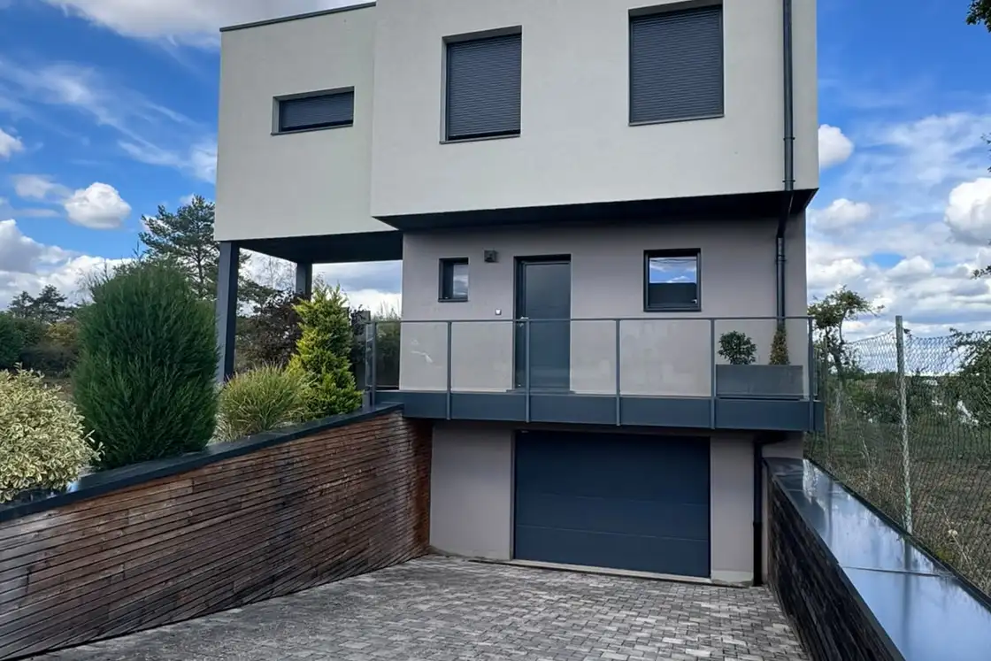 Volume haut d’un bâtiment contemporain recouvert d’un enduit de finition clair.